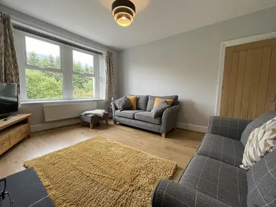 a living room with a couch and a tv at Glenderamackin Cottage in Threlkeld