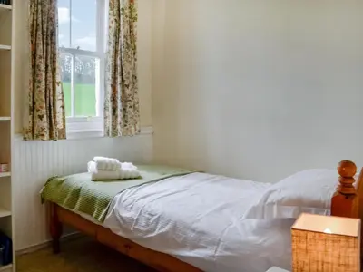 a bed in a room with a window at Field Cottage in Old Bridge of Urr