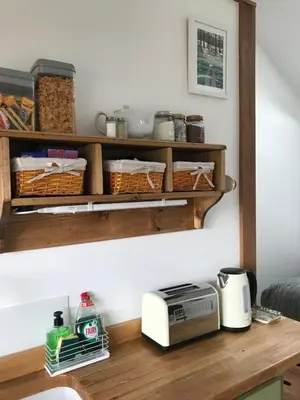 a kitchen counter with wooden shelves and a toaster at The Nook at Claremont House CA12 4LT in Keswick