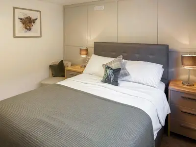 a bedroom with a large bed and two night stands at Thistle Cottage in Portpatrick
