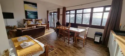 a living room with a table and a dining room at Scafell Cottage on The Big 