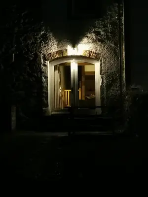 a dark room with a window with a bench at night at Rainors farm cottage in Gosforth