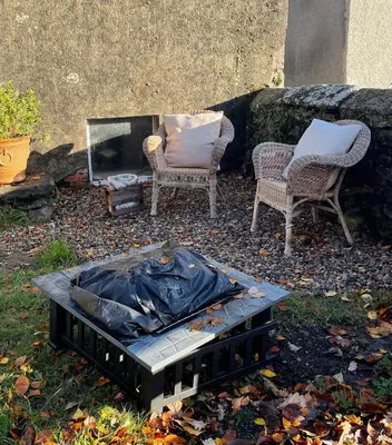 two chairs and a fireplace in a yard at 1-Bed studio Apartment nr Cockermouth in Cockermouth
