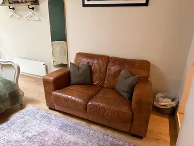 a brown leather couch sitting in a living room at 1-Bed studio Apartment nr Cockermouth in Cockermouth