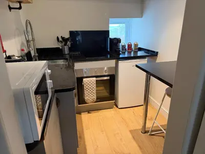 a kitchen with an oven and a table in it at 1-Bed studio Apartment nr Cockermouth in Cockermouth