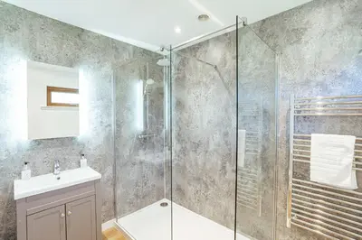 a bathroom with a glass shower and a sink at Kestrel Lodge 6 with Hot Tub in Newton Stewart