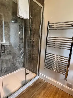 a shower with a glass door in a bathroom at Osprey Lodge 8 with Hot Tub in Newton Stewart