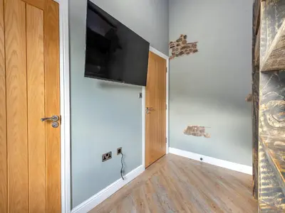 a hallway with a flat screen tv on a wall at The Barn Owl - Uk36217 in Bowness-on-Solway