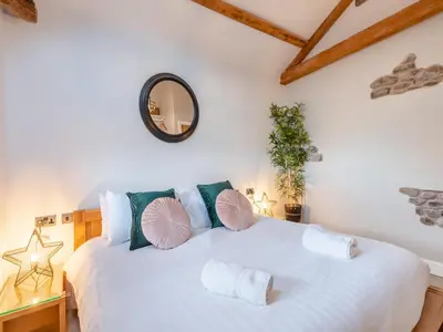 a bedroom with a large white bed with pillows at The Barn Owl - Uk36217 in Bowness-on-Solway