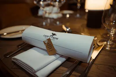 a table with a white napkin on a wooden table at Dundonald Links in Dreghorn