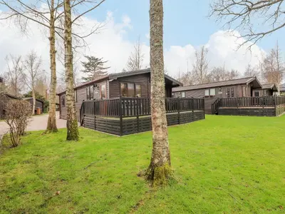 a log house with a yard with trees at The Fold in Keswick