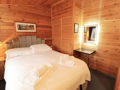 a bedroom with two beds in a wooden cabin at The Fold in Keswick