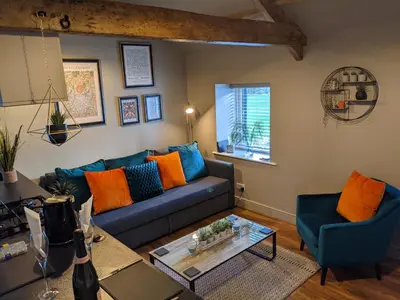 a living room with a blue couch and two chairs at The Stables - Bankshill in Lockerbie