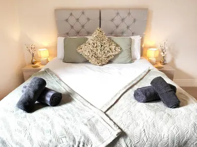a bedroom with a bed with two towels on it at Douglas House, near Hospital, attractive and comfy 2 bedroom House with enclosed yard to rear in Carlisle