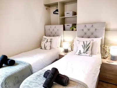 two twin beds in a room with white walls at Douglas House, near Hospital, attractive and comfy 2 bedroom House with enclosed yard to rear in Carlisle
