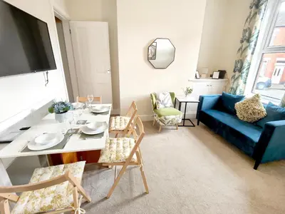 a living room with a table and a blue couch at Douglas House, near Hospital, attractive and comfy 2 bedroom House with enclosed yard to rear in Carlisle