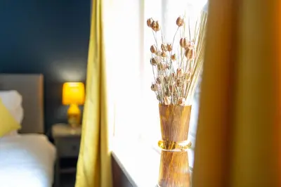 a vase with flowers sitting on a window sill at Russell House, Large townhouse spacious and modern with ground floor bedroom and shower room and free parking in Harraby