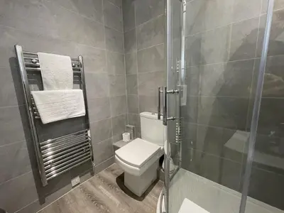 a bathroom with a toilet and a glass shower at Gretaside in Keswick