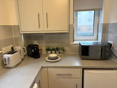 a kitchen with a counter top with a microwave at Kinfirth Apartment in Ayr