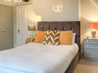 a bedroom with a large bed with orange pillows at Upton Down in Keswick