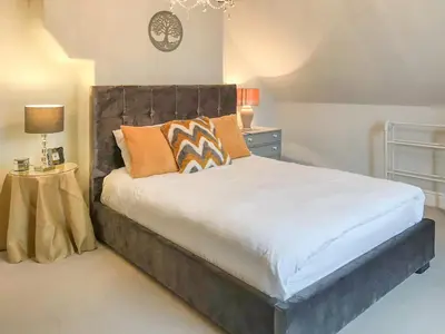 a bedroom with a large bed with orange pillows at Upton Down in Keswick