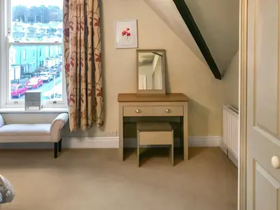 a dressing table with a mirror and a window at Upton Down in Keswick