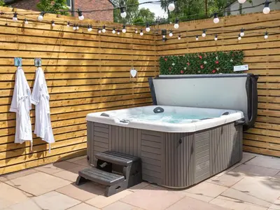 a jacuzzi tub in a backyard with a fence at Highgate in Kirklinton
