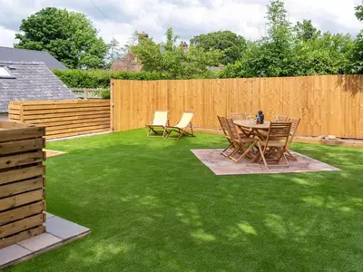 a backyard with a table and chairs on grass at Highgate in Kirklinton