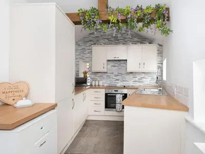 a kitchen with white cabinets and purple flowers on the ceiling at Highgate in Kirklinton