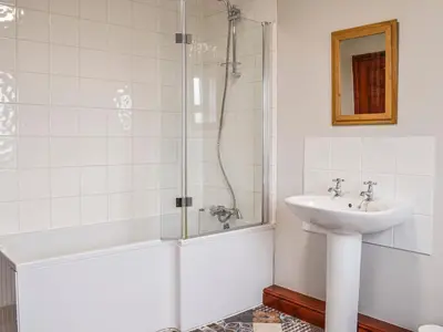 a white bathroom with a sink and a shower at Ellerton Croft in Wreay
