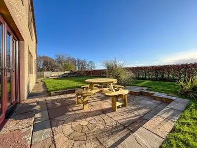 a picnic table on a patio next to a building at Ellerton Croft in Wreay
