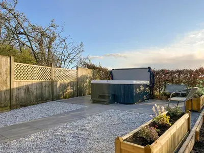 a backyard with a hot tub and a fence at Ellerton Croft in Wreay