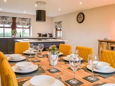 a dining room with a wooden table with glasses on it at Ellerton Croft in Wreay