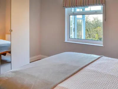 a bedroom with a bed and a window at Clarksburn Blue in Monreith