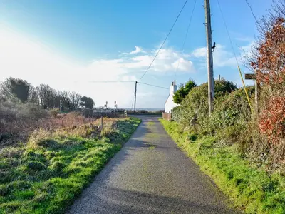 a road with a small white church on the side at Clarksburn Blue in Monreith