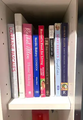 a row of books sitting on a book shelf at Wee Silverburn in Whiting Bay