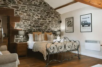 a bed in a room with a stone wall at Highside Farm in Bassenthwaite