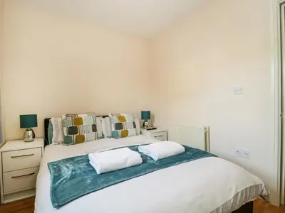 a bedroom with a large white bed with two pillows at Fox's Retreat in Keswick