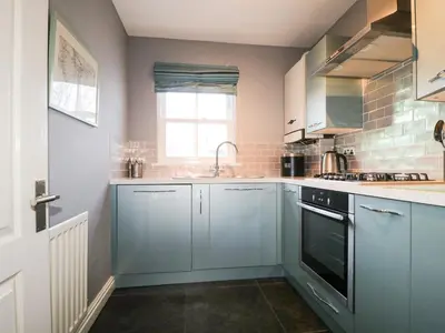 a kitchen with blue cabinets and a sink and a window at Fox's Retreat in Keswick