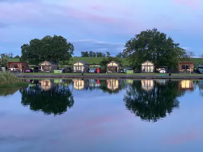 a group of houses on the shore of a lake at Arranview Lochside Pods & Lodges all with private Hot-tubs in Fenwick