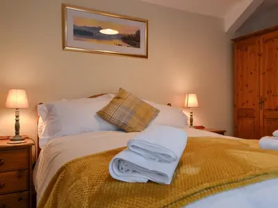a bedroom with a bed with towels on it at Scalelands Cottage in Frizington