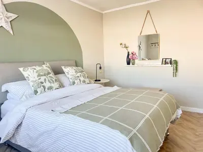 a bedroom with a bed with a gray and white comforter at Mossdale Cottage in Dalmellington