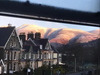 a painting of a house in front of a mountain at Skiddaw View in Keswick