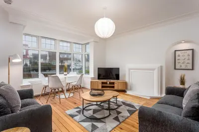 a living room with two couches and a table at Wellington View - Donnini Apartments in Ayr