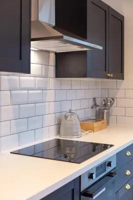 a kitchen with black cabinets and a stove top at Wellington View - Donnini Apartments in Ayr