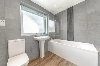 a bathroom with a white tub and a sink at Cherry Garth HOT TUB HIRE AVAILABLE in Keswick