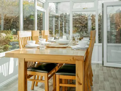a wooden dining room table with chairs and a tableastery at Drumwherry By The Sea in Monreith