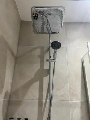a shower in a bathroom with a shower head at Keswick Ground floor apartment with parking in Keswick