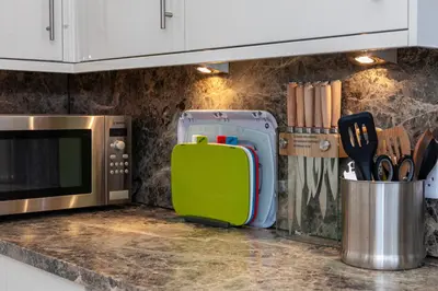 a kitchen counter with a green suitcase next to a microwave at Keswick Ground floor apartment with parking in Keswick