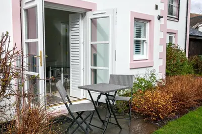a table and two chairs sitting on a patio at Keswick Ground floor apartment with parking in Keswick